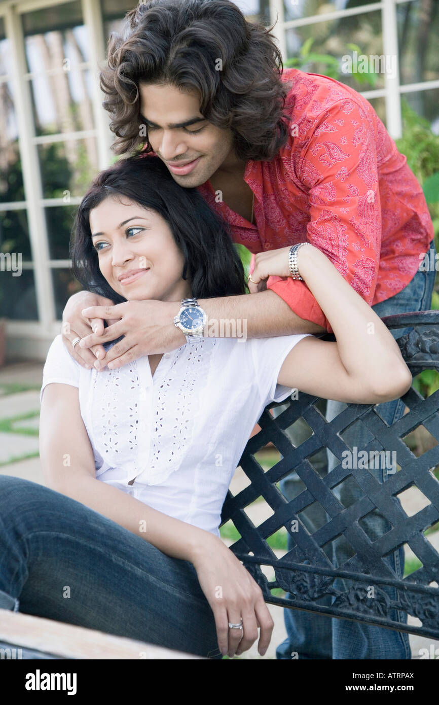 Young man embracing a young woman from behind Stock Photo - Alamy