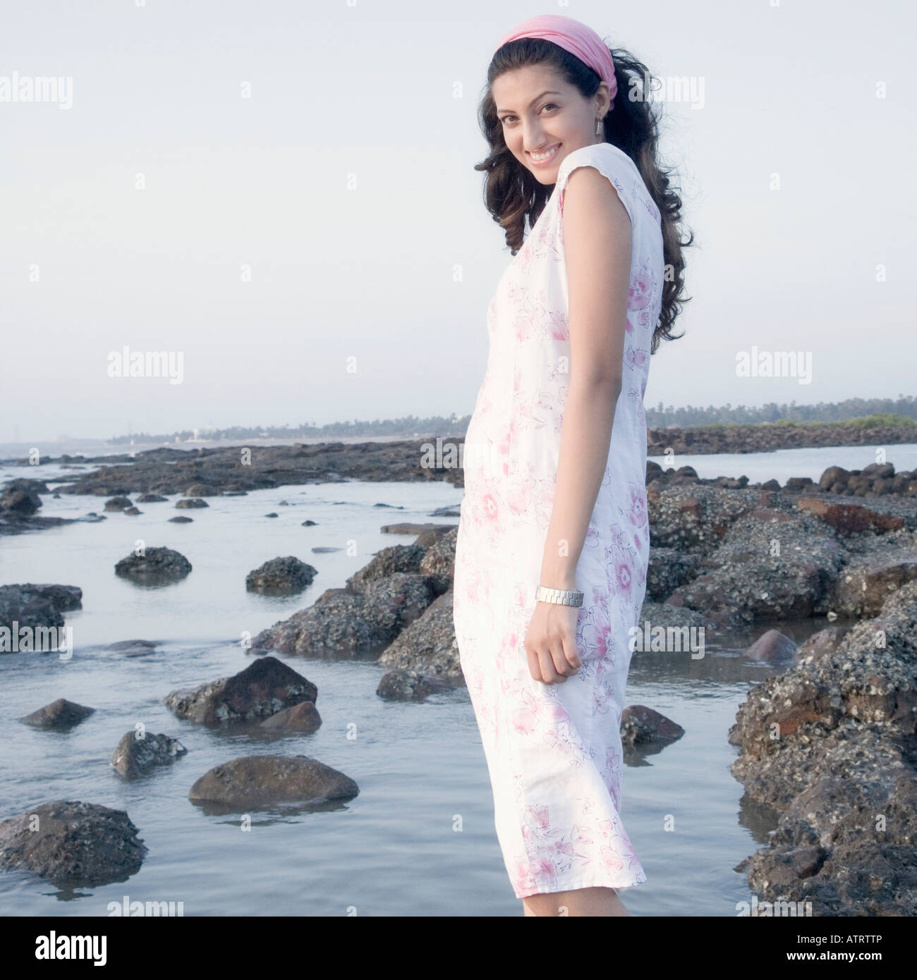 Portrait of a young woman standing on the beach and smiling Stock Photo ...