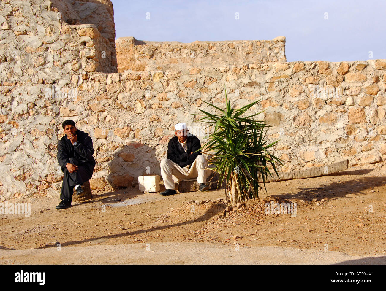 Local guides wait for tourists outside the Berber granary Qasr al Hadj Libya Stock Photo