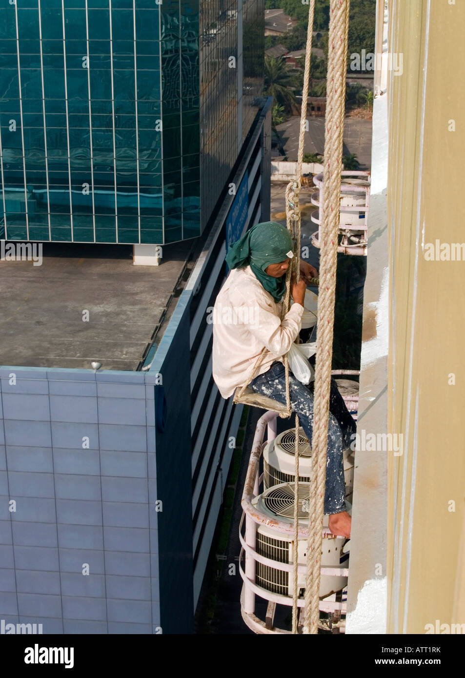 painter working up on highrise building in Bangkok Stock Photo