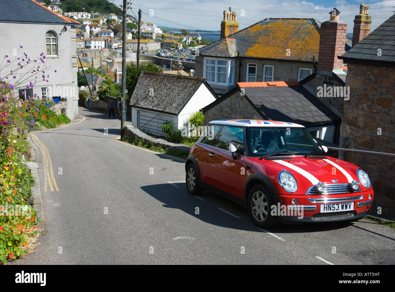 A red Mini Cooper parked in the Cornish fishing town of Mousehole in the United Kingdom. Stock Photo