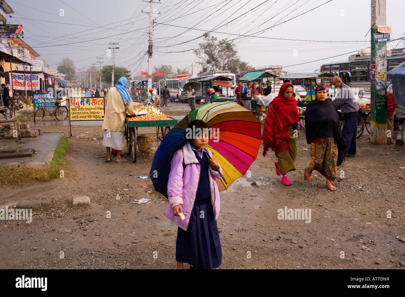 A young girl with a multi colored umbrella on the street in Nepal Stock