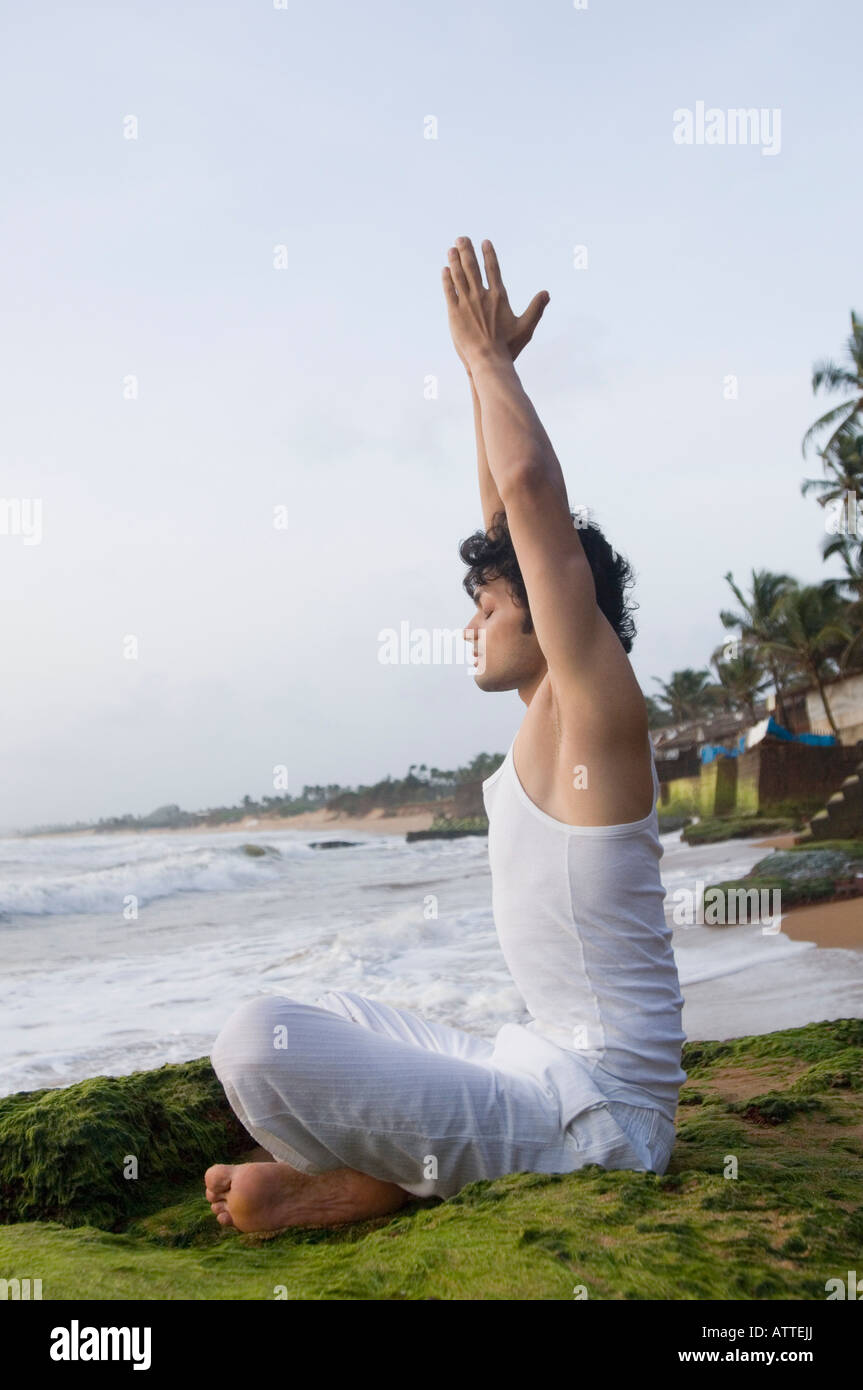 Side profile of a young man meditating on the beach Stock Photo - Alamy