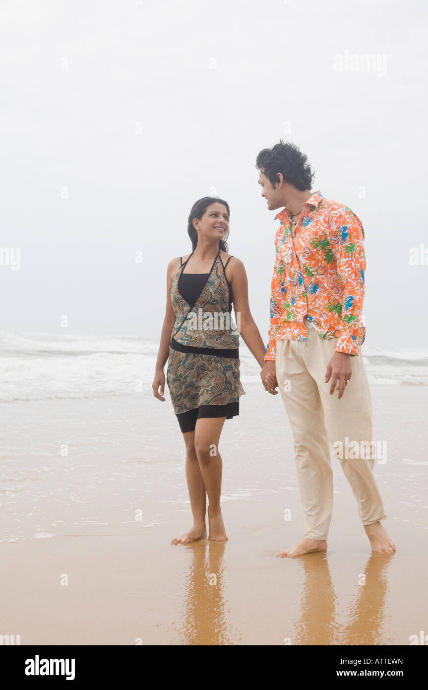 Young couple walking with holding hands on the beach Stock Photo