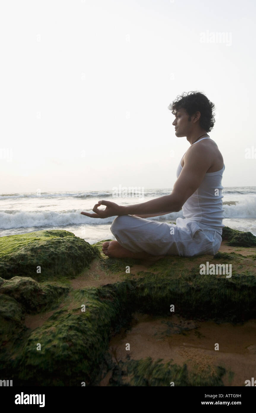 Side profile of a young man meditating on the beach Stock Photo - Alamy