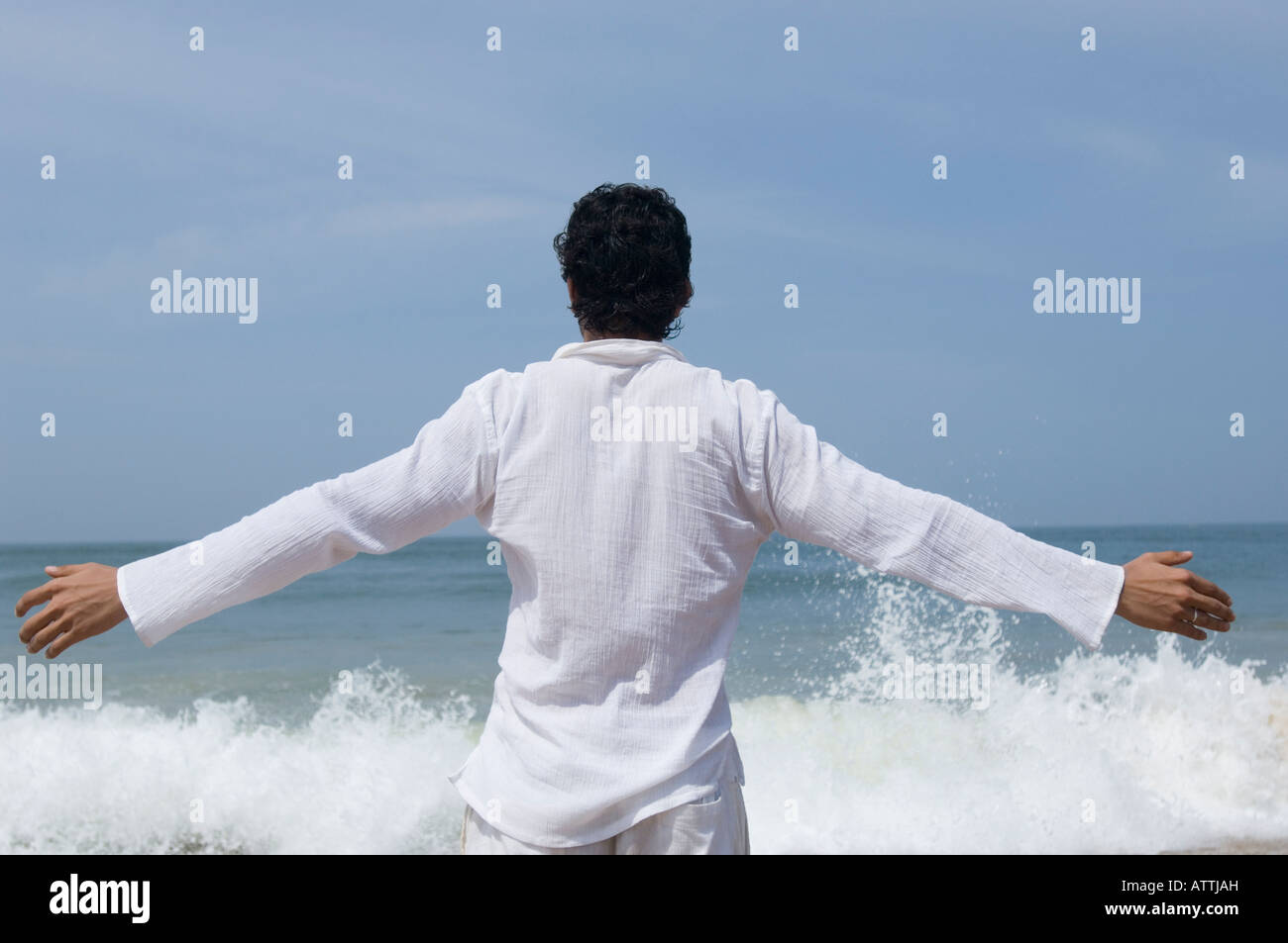 Rear view of a young man standing on the beach Stock Photo