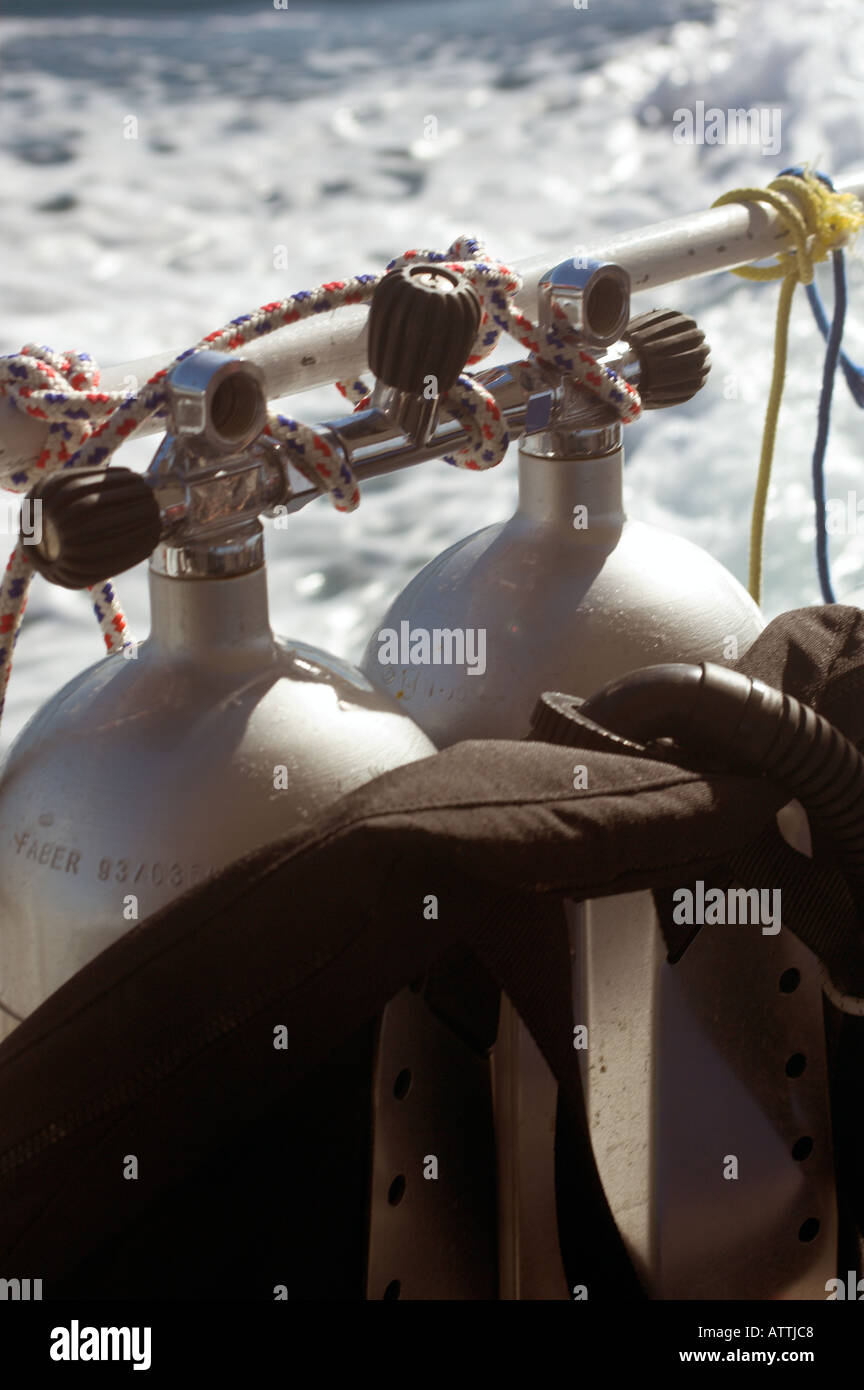 Manifolded twin scuba diving cylinders tied on rail of dive boat Stock