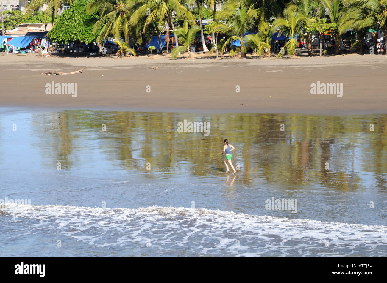 A woman runs along the beach near the cruise ship dock in Puntarenas