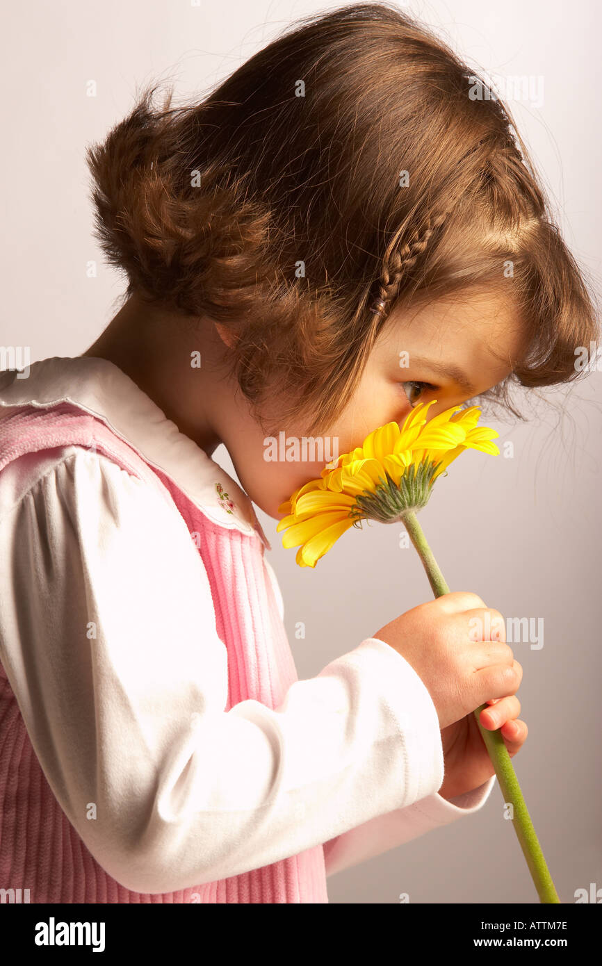 Little girl smelling flower Stock Photo - Alamy