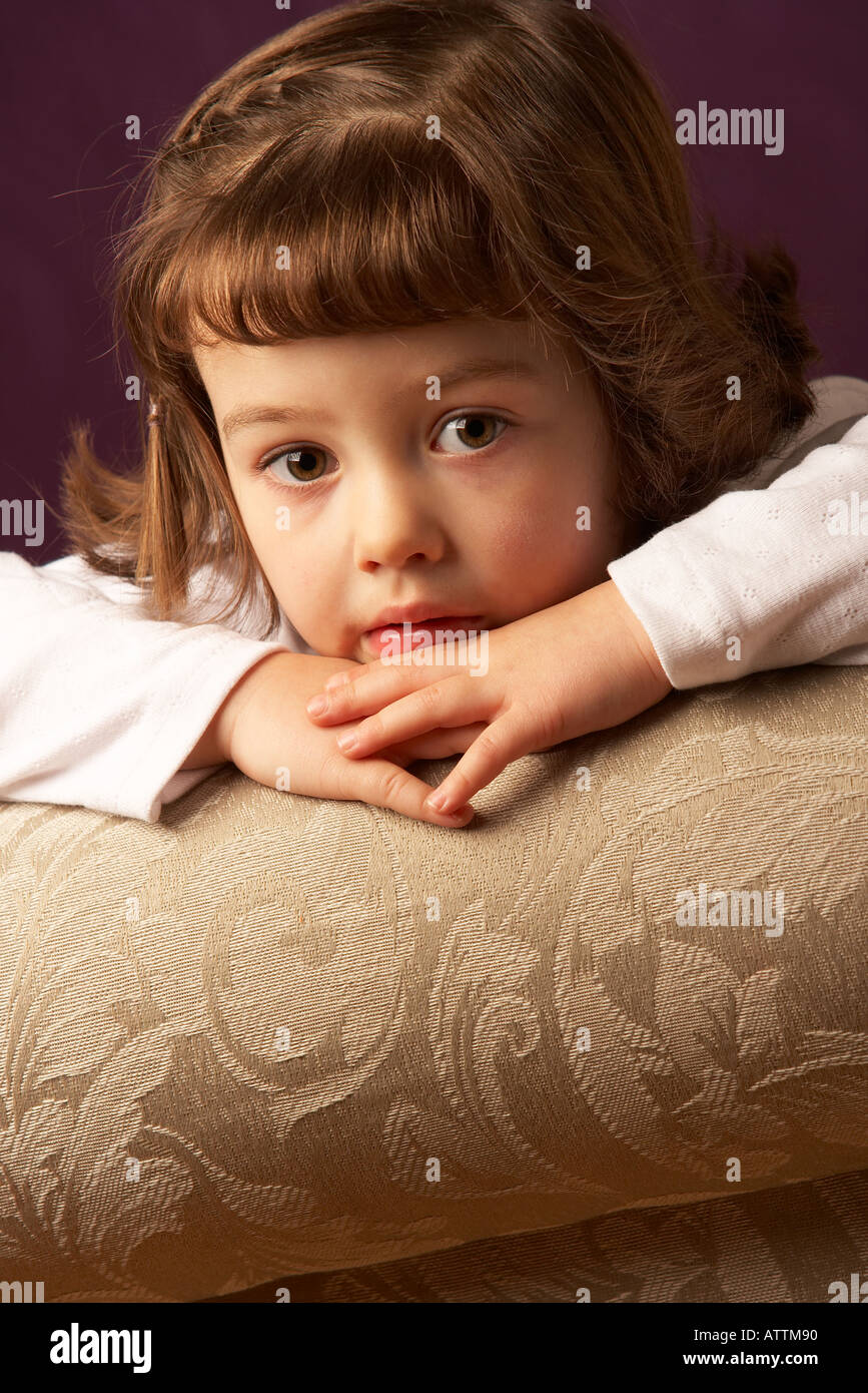 Young girl sitting with chin on hands Stock Photo - Alamy
