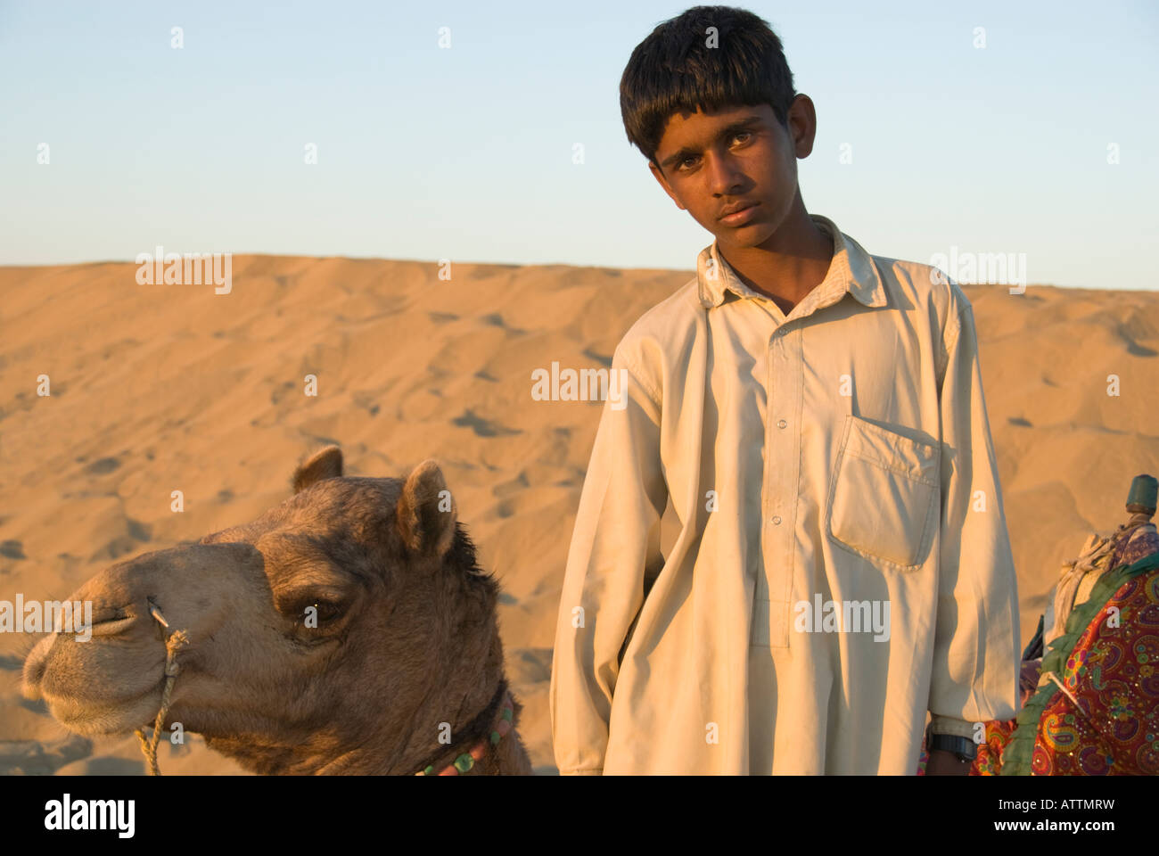Young camel driver with his camel in the Thar Desert of Rajasthan Stock Photo