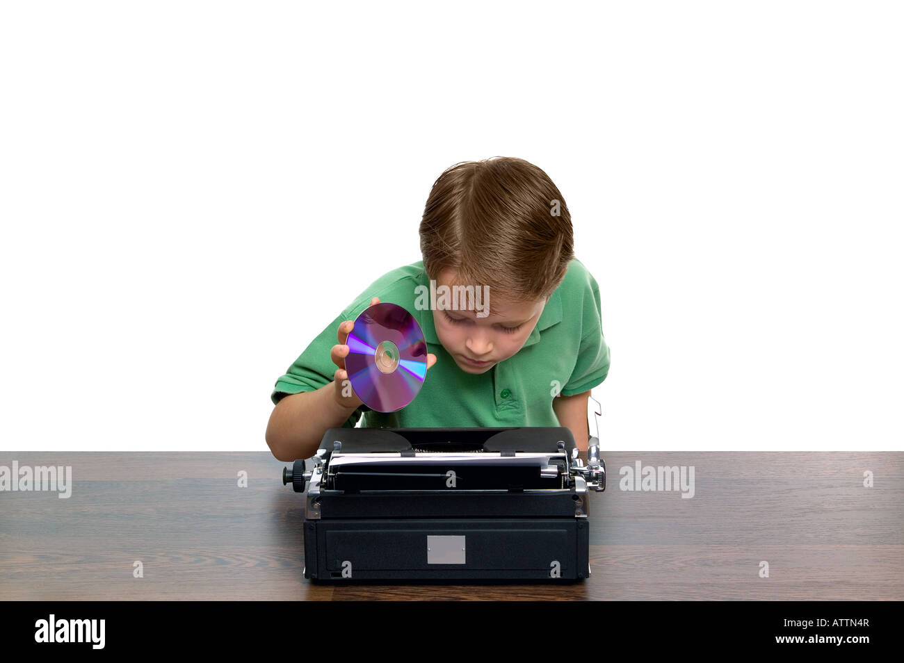 Young boy trying to work out where the DVD goes in this strange looking laptop Concept of youth and retro technology Stock Photo