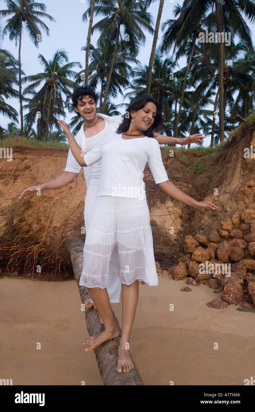 Young couple walking on a tree trunk Stock Photo