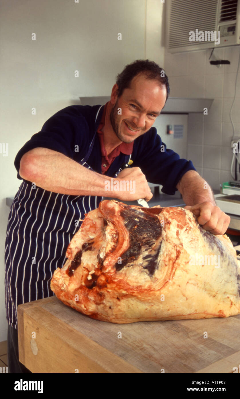 Butcher carving a beef joint Stock Photo Alamy