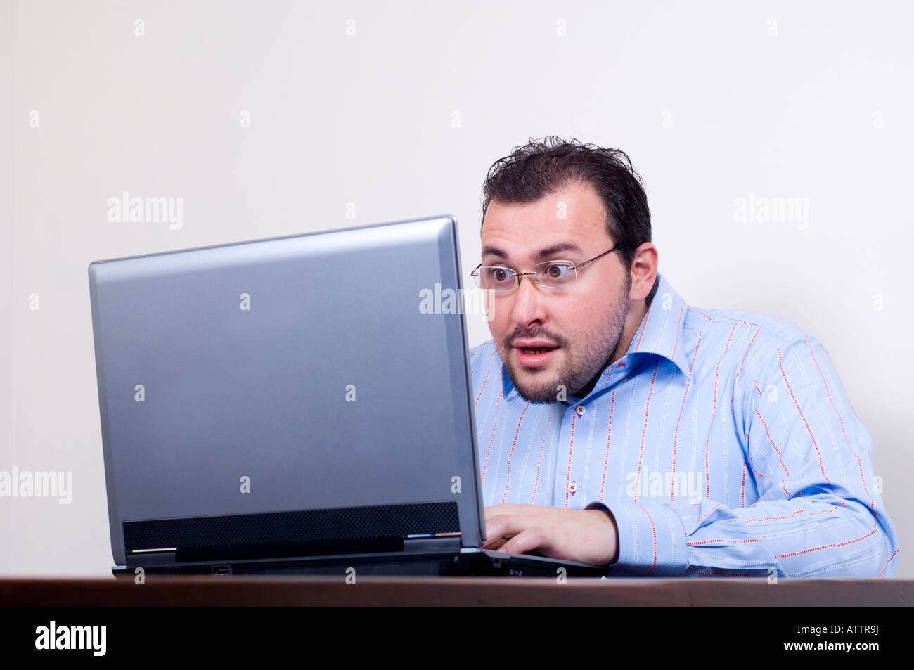 Man surprised looking at laptop Stock Photo