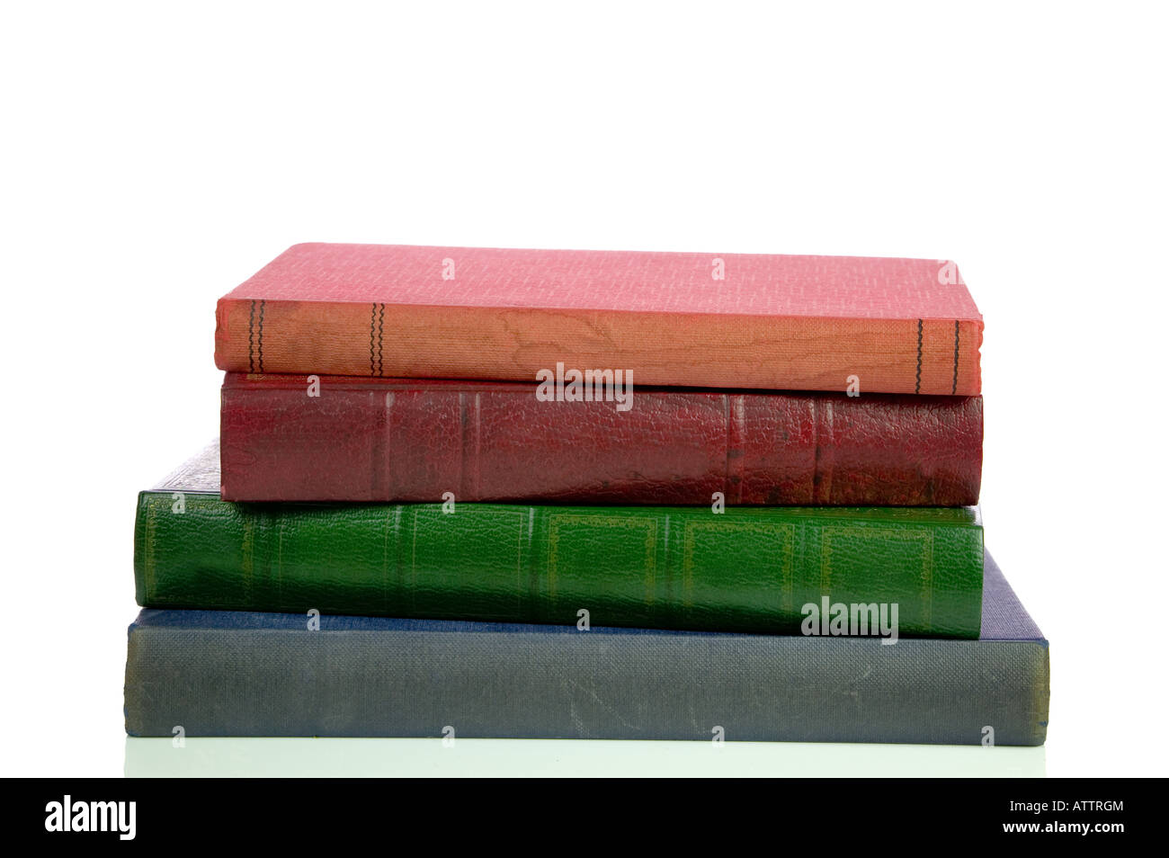 Four old faded and stained books in a pile isolated on a white background Stock Photo