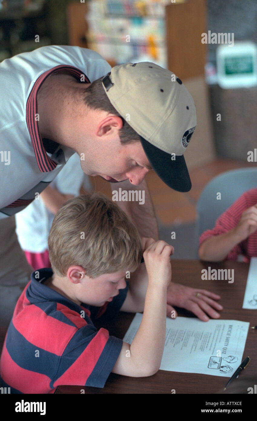 Father and son ages 30 and 5 studying bicycle safety test. Youth