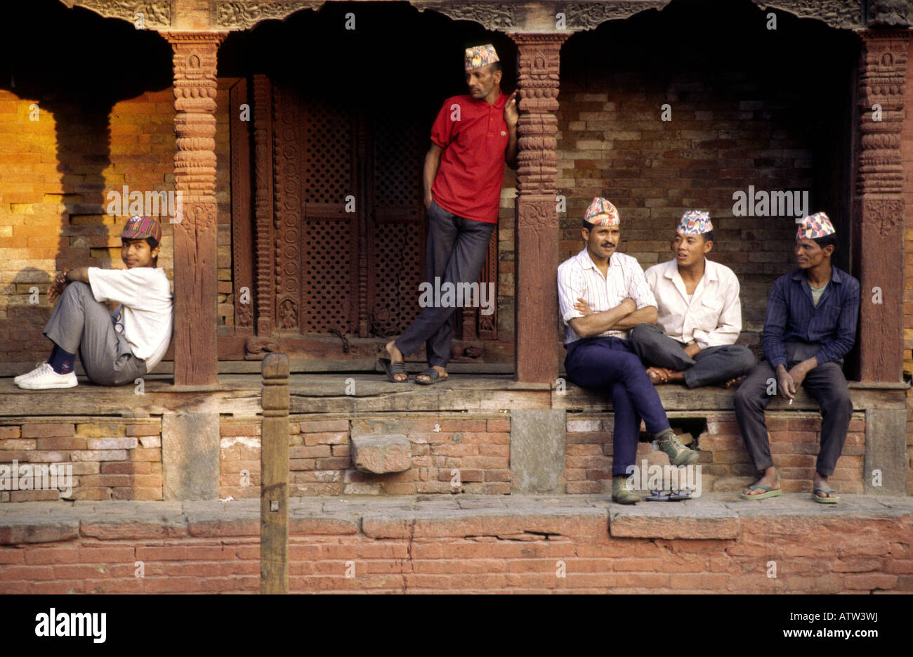 Nepali men rest under the arches of an old building in Durbur Square in Kathmandu in Nepal Stock Photo