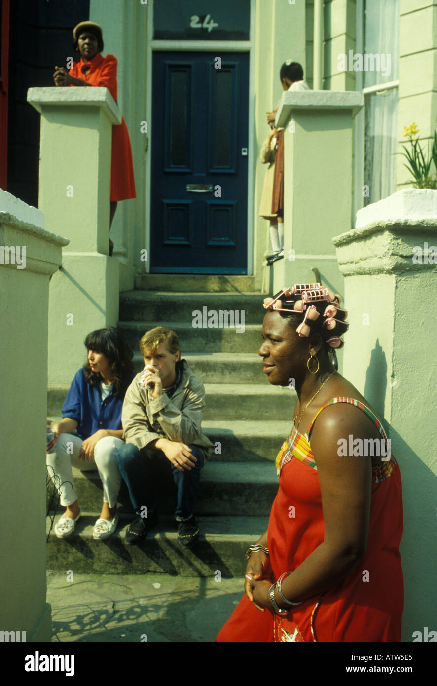 Black British woman hair in curlers outside her home. She is getting ready for the annual Notting Hill Carnival, London 1991 1990s UK HOMER SYKES. Stock Photo