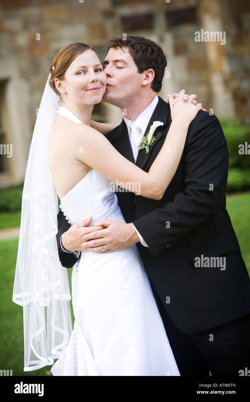 A happy groom kissing his beautiful bride on the cheek Stock Photo - Alamy