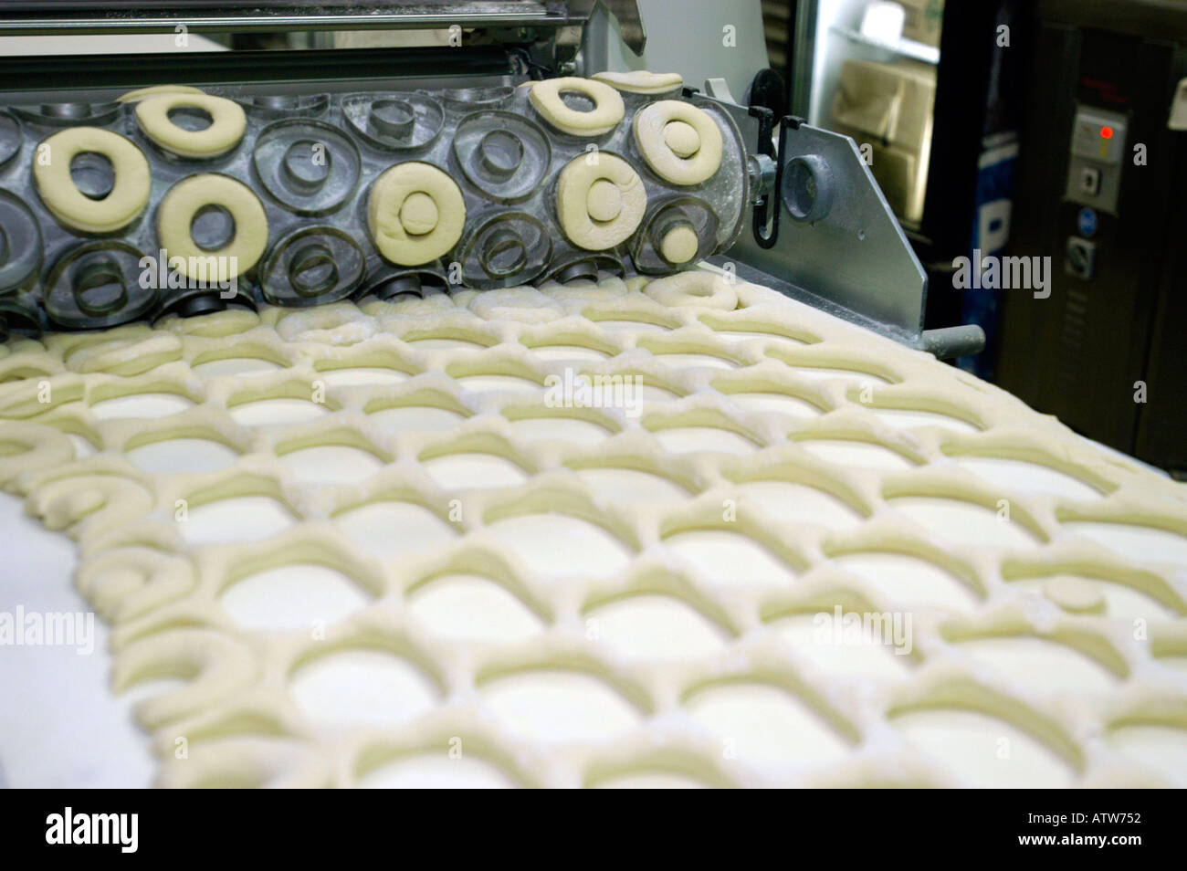A die cutting machine makes donuts in a New York City Dunkin Donuts ...