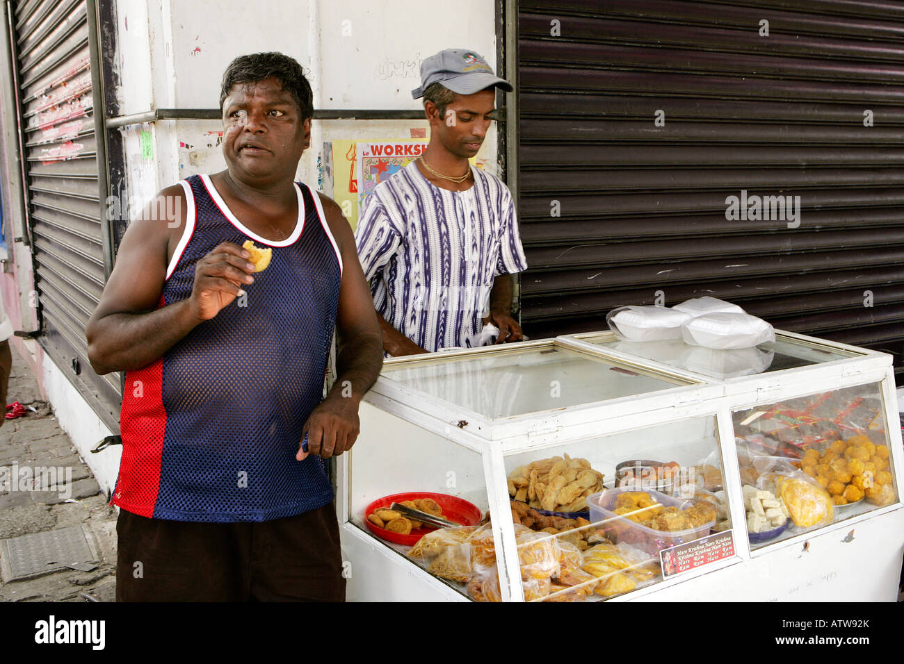 Trader and customer eating local food at Port Louis Market, Port Louis, Mauritius Stock Photo