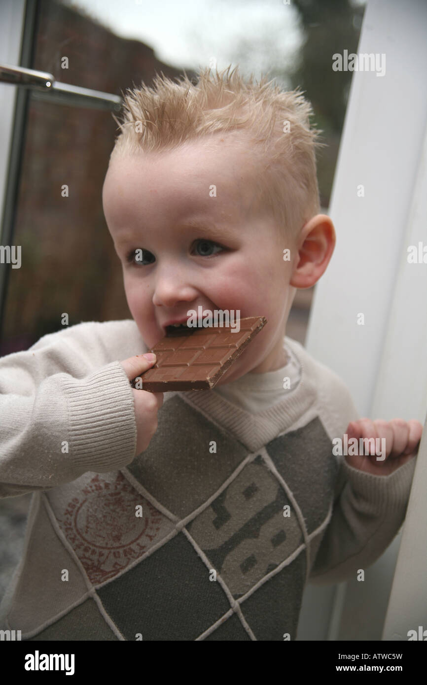 A toddler eating a large bar of milk chocolate Stock Photo Alamy