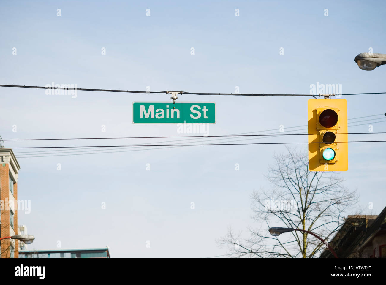 Street sign reading main street and green traffic light Stock Photo