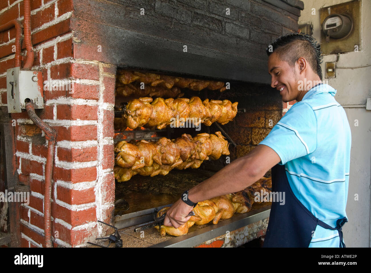 https://c8.alamy.com/comp/ATWE2P/mexico-guanajuato-young-male-putting-whole-chickens-on-rotisserie-ATWE2P.jpg