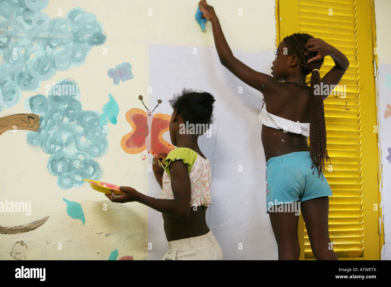 Child in favela community centre painting mural as pat of charity aid project, Rio de Janeiro, Brazil, South America Stock Photo
