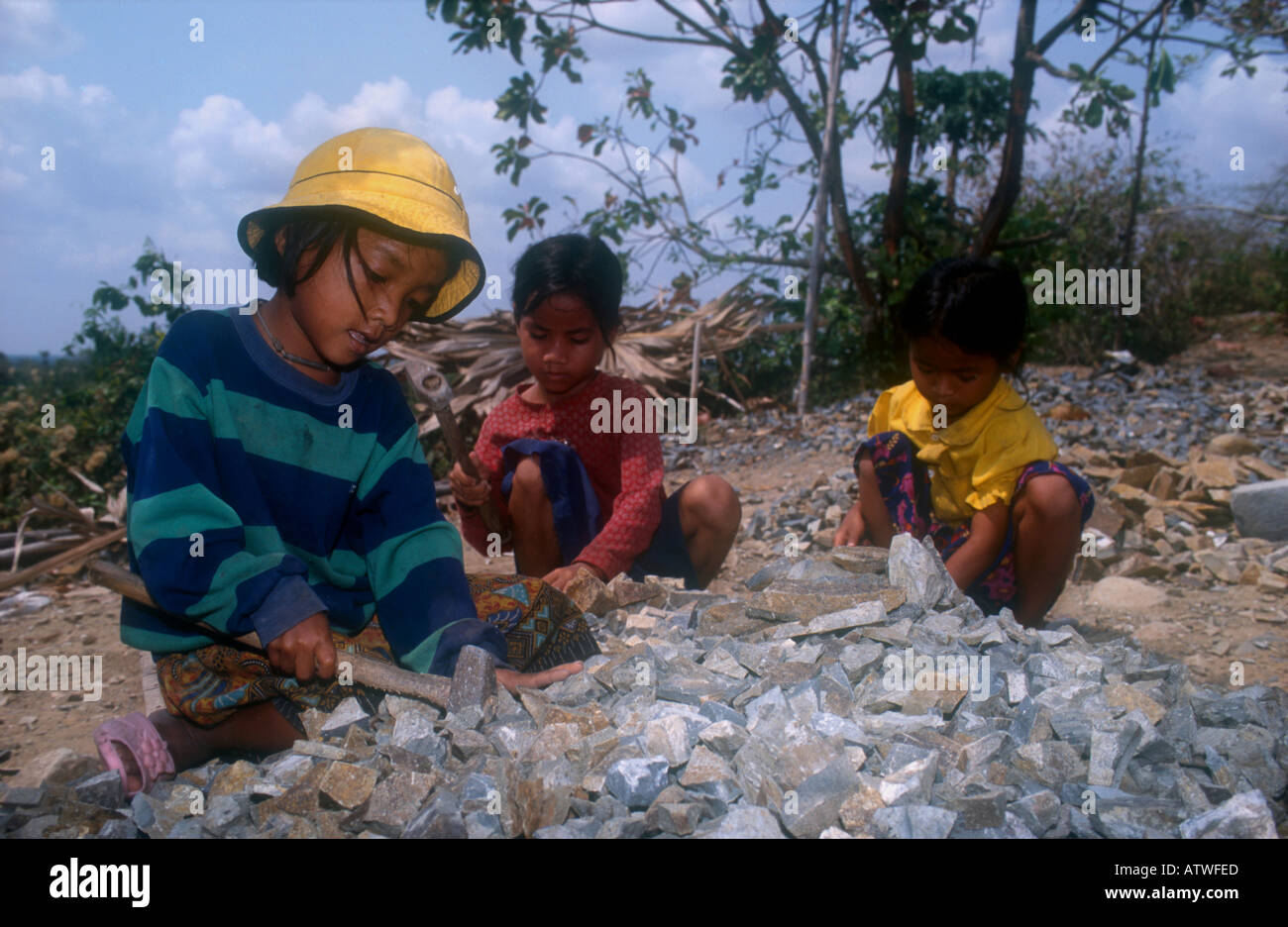 Child labourers work in a quarry breaking stones to build roads. Takeo ...