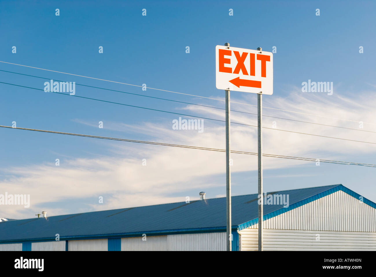 Parking lot exit sign with arrow against a blue sky Stock Photo