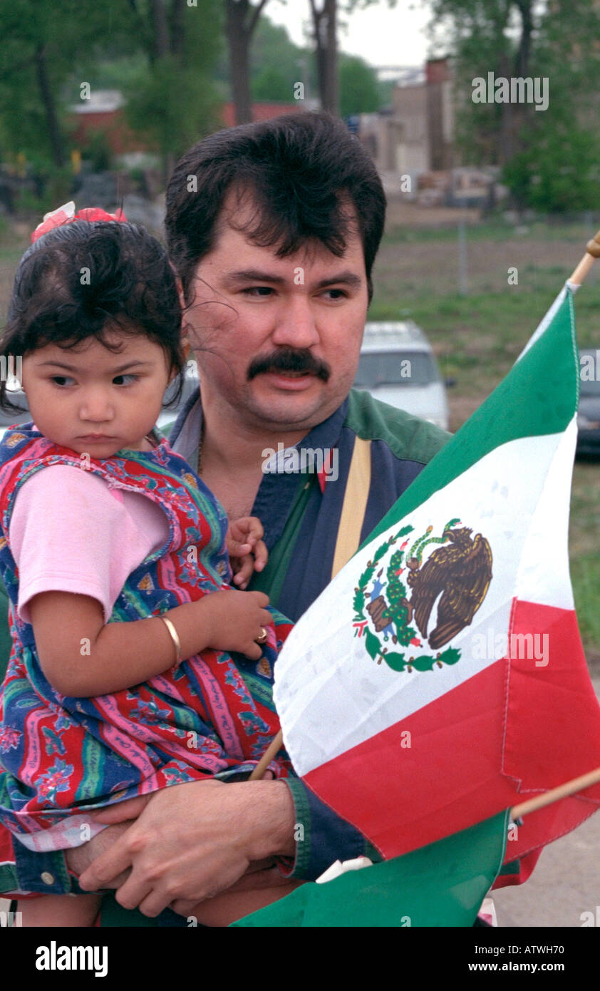 Latino father holding daughter age 32 and 2 holding Mexican flag at Cinco de Mayo Festival. St Paul Minnesota USA Stock Photo