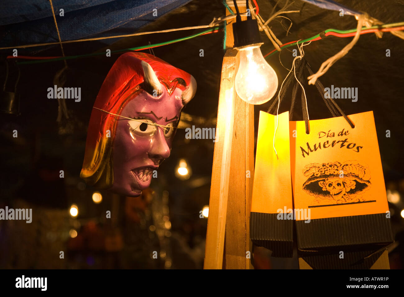 MEXICO Guanajuato Shopping bag for Day of the Dead scary female mask at night lightbulb in booth Stock Photo