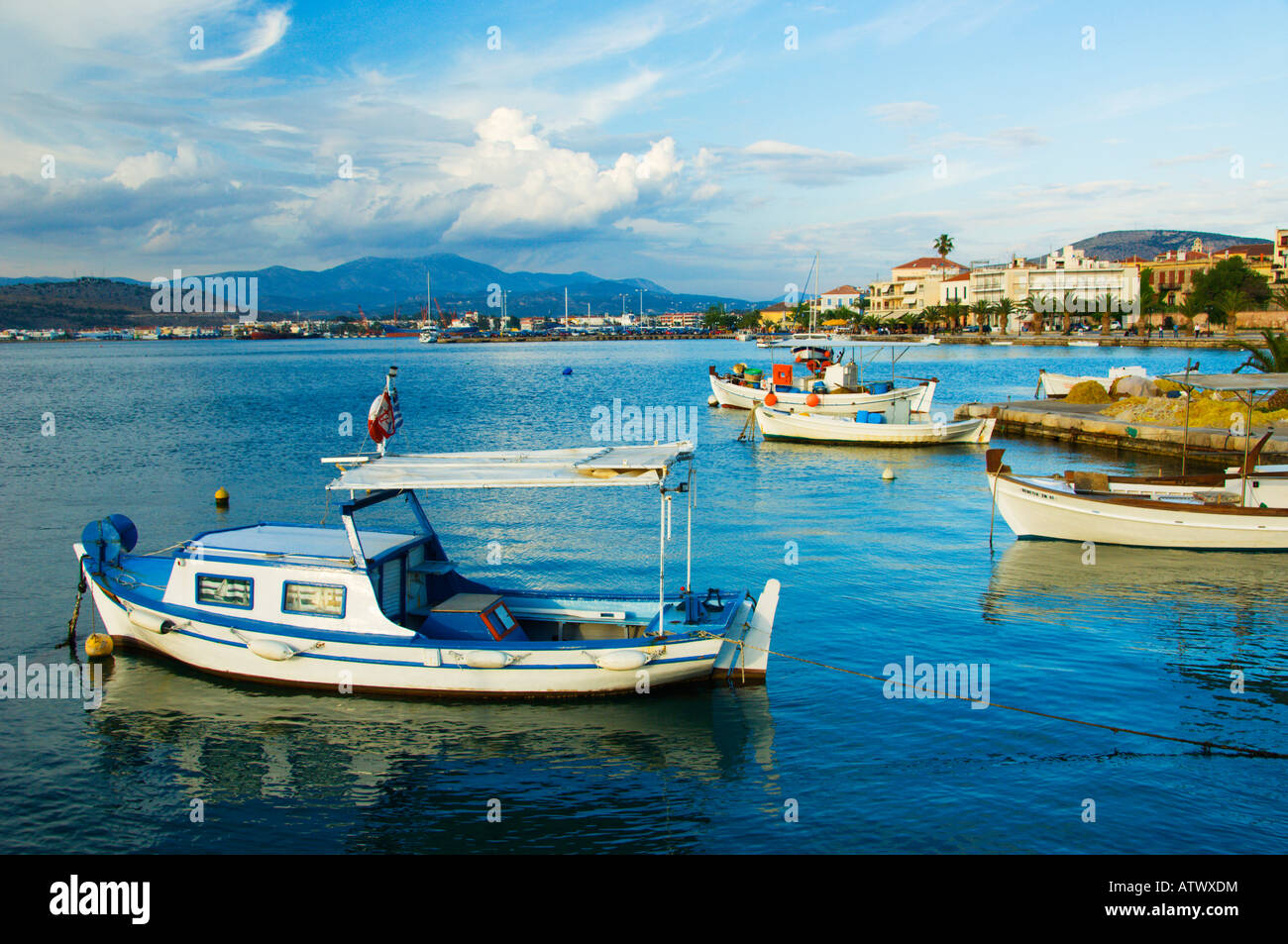 Colorful fishing boats in the harbour with relfections and the Palmidi Fortress above Nafplio Greece Stock Photo