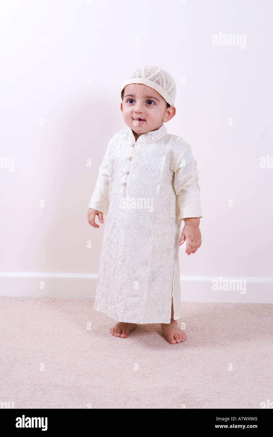 One year old Arabic boy wearing traditional Islamic outfit Jilbab standing  looking away smiling Stock Photo - Alamy