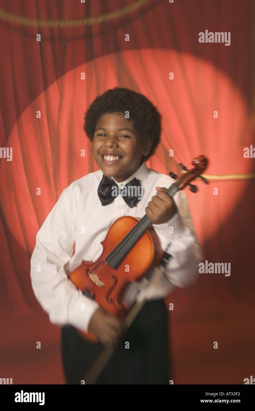 Boy on stage holding a violin Stock Photo