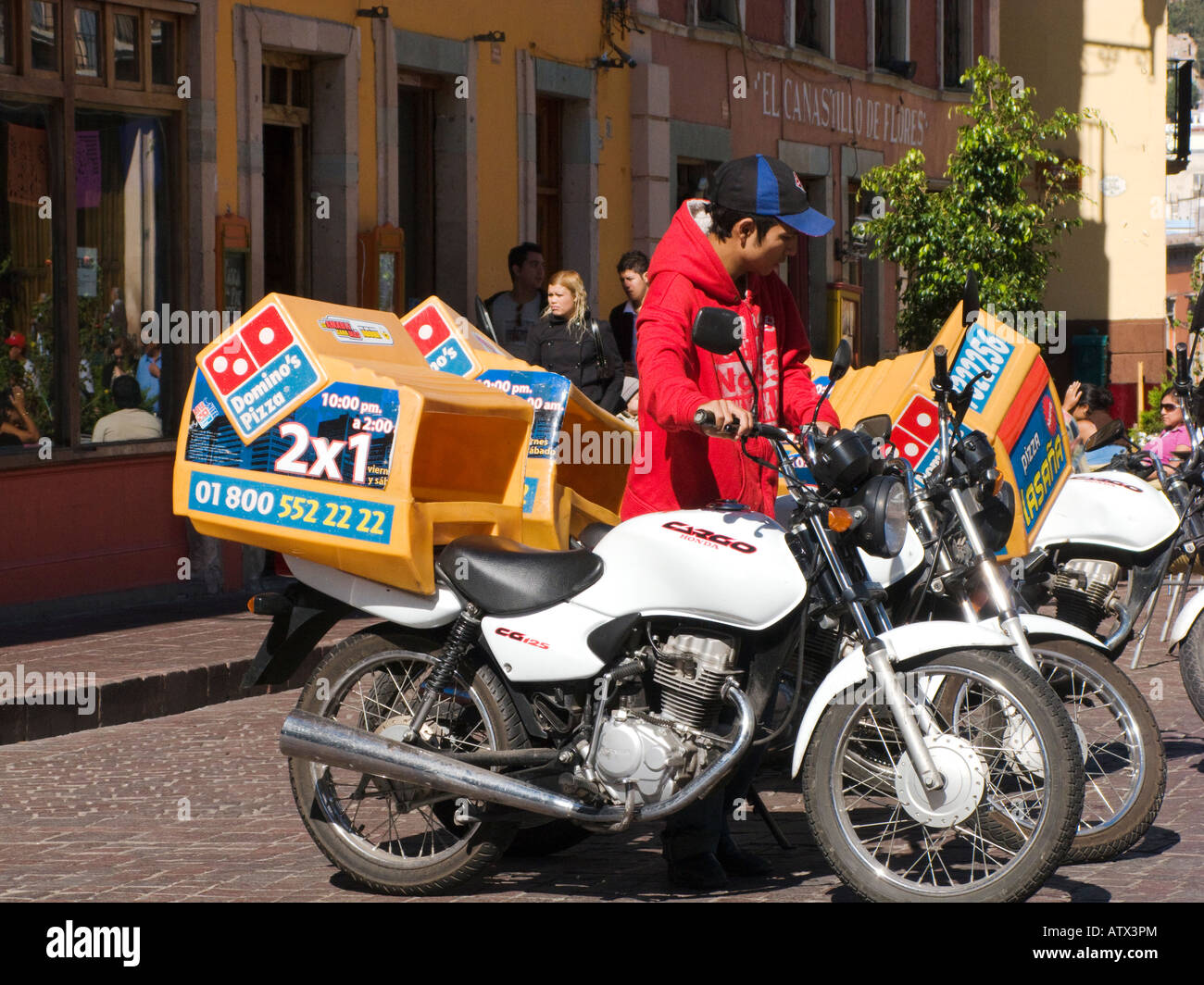 MEXICO Guanajuato Mexican teenage boy with motorcycle for Domino pizza delivery on city street Stock Photo