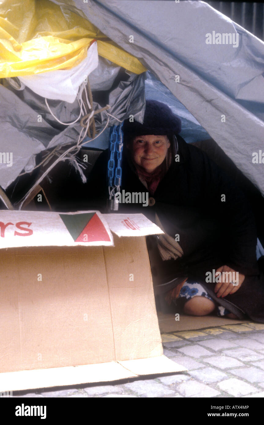 Homeless woman living under canvas stretch over two prams, London Stock