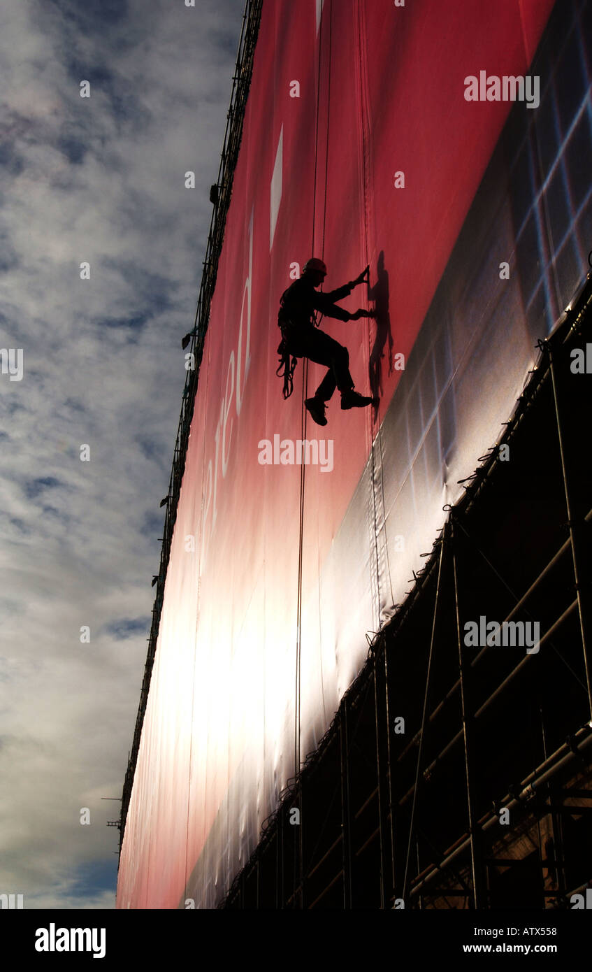 AN ABSEIL POSTER RIGGER AT WORK ON THE LARGEST ADVERTISING BANNER IN THE WORLD AT FORT DUNLOP BIRMINGHAM UK PIC JOHN ROBERTSON Stock Photo
