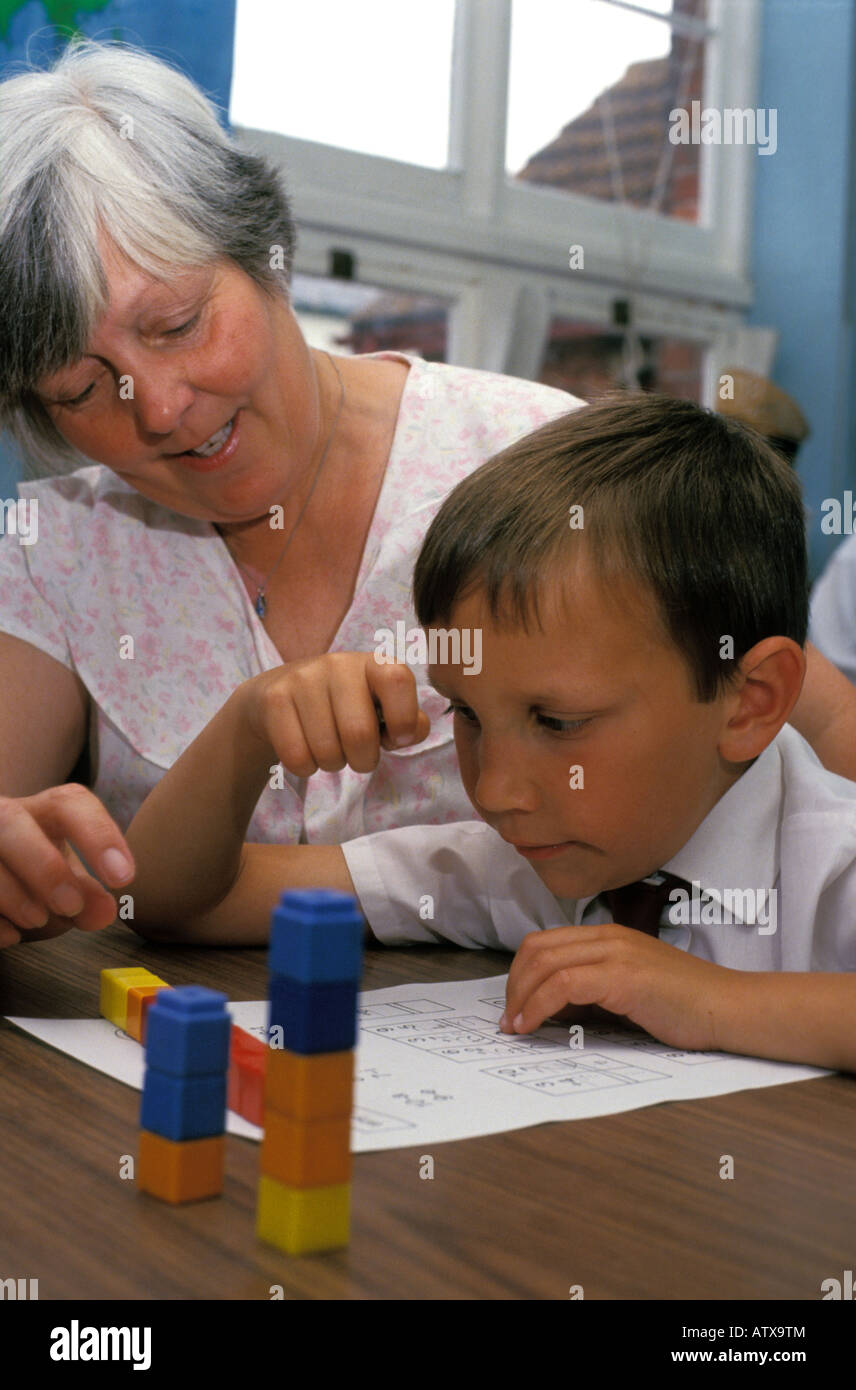 Teacher giving extra help to a dysbraxic child Stock Photo