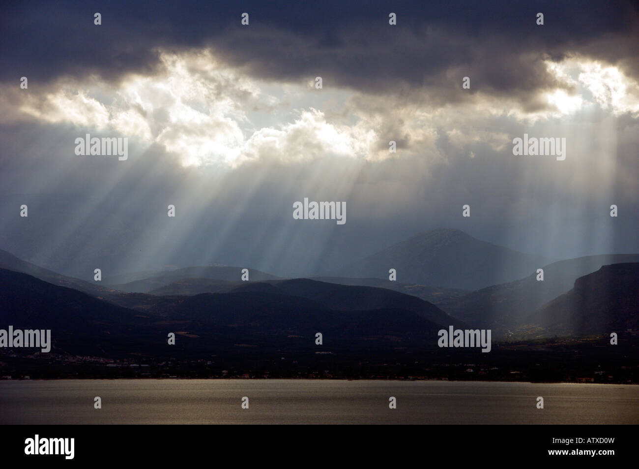 Sunburst rays illuminate mountains and the bay near Nafplio Greece Stock Photo