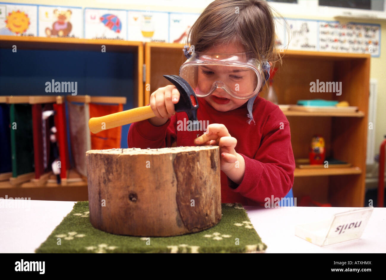 Young Child doing wood work for co ordination at Montessori school in Kensington London Stock Photo