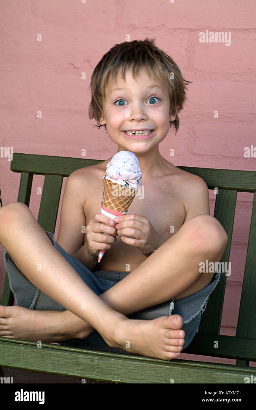 Boy eating ice cream cone on a hot summers day. Stock Photo