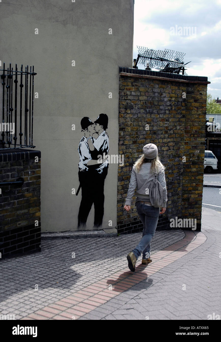 since removed Banksy kissing Policemen in Ladbroke Grove with passing person Stock Photo