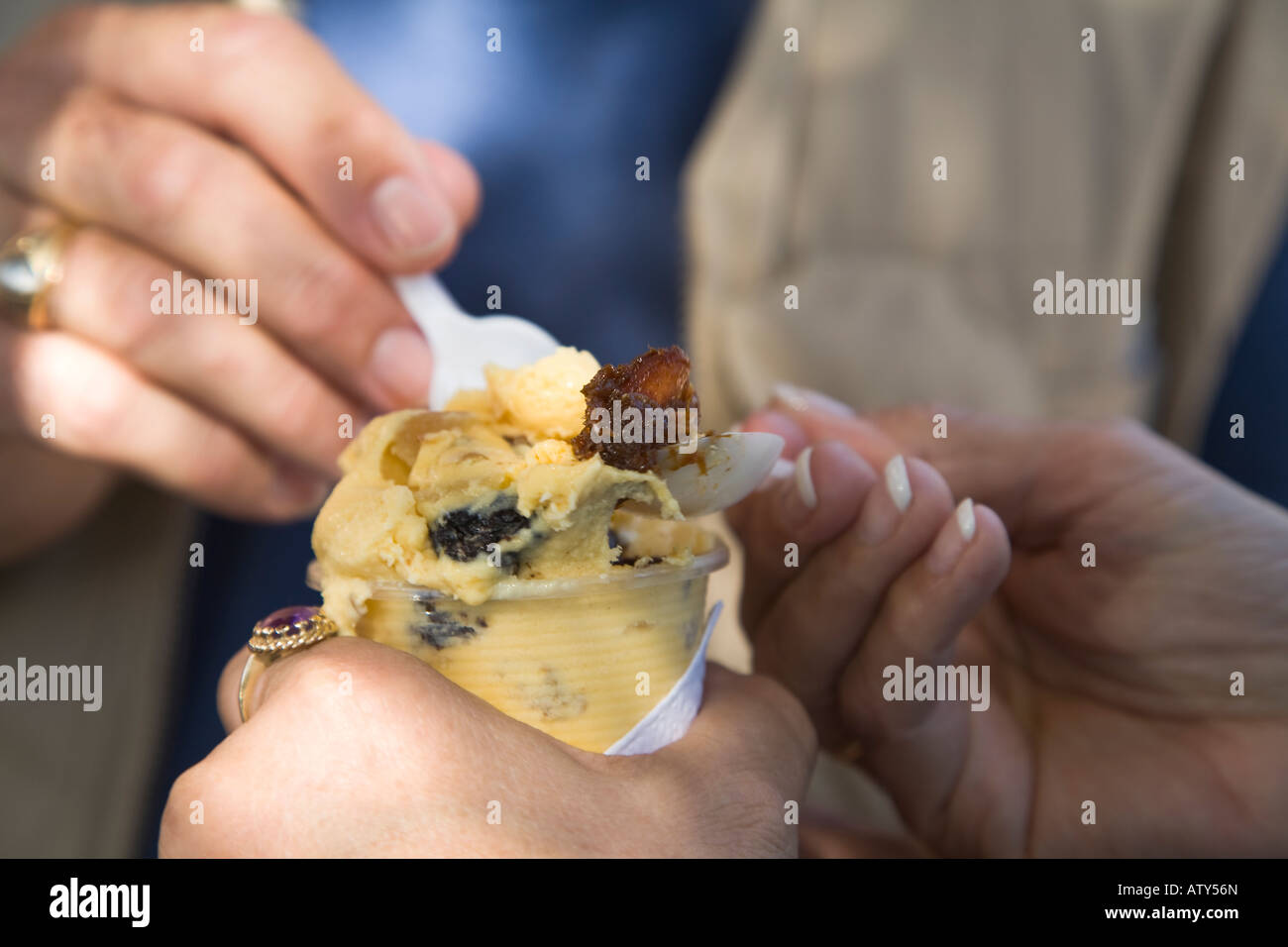 MEXICO Dolores Hidalgo Hands of man and woman eating ice cream purchased from street vendor in plaza local specialty Stock Photo