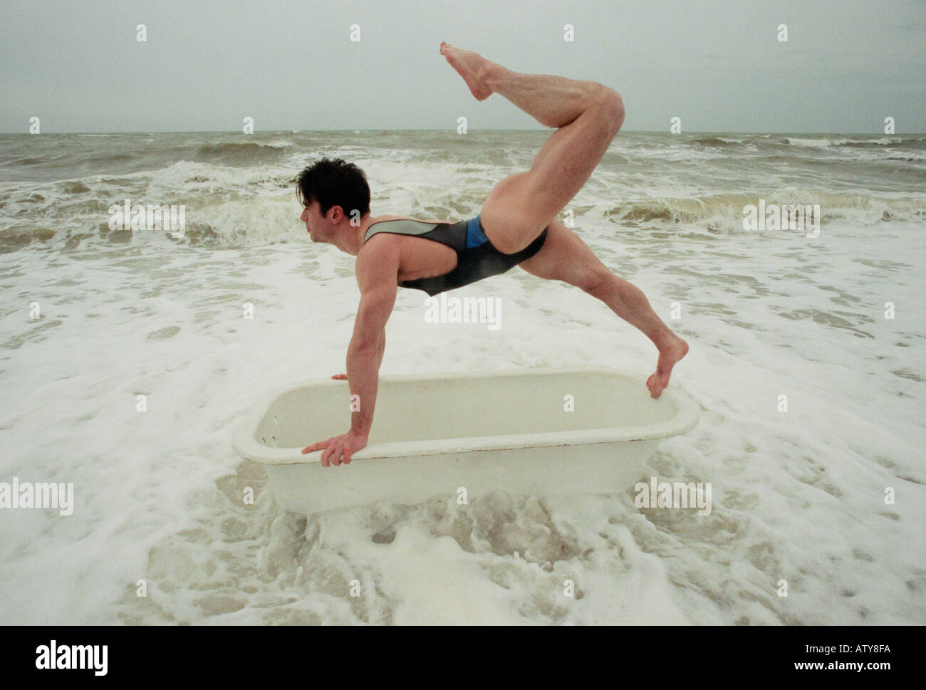 A performer at Brighton Festival rehearses his surreal  bathtub based one man show in the sea Stock Photo
