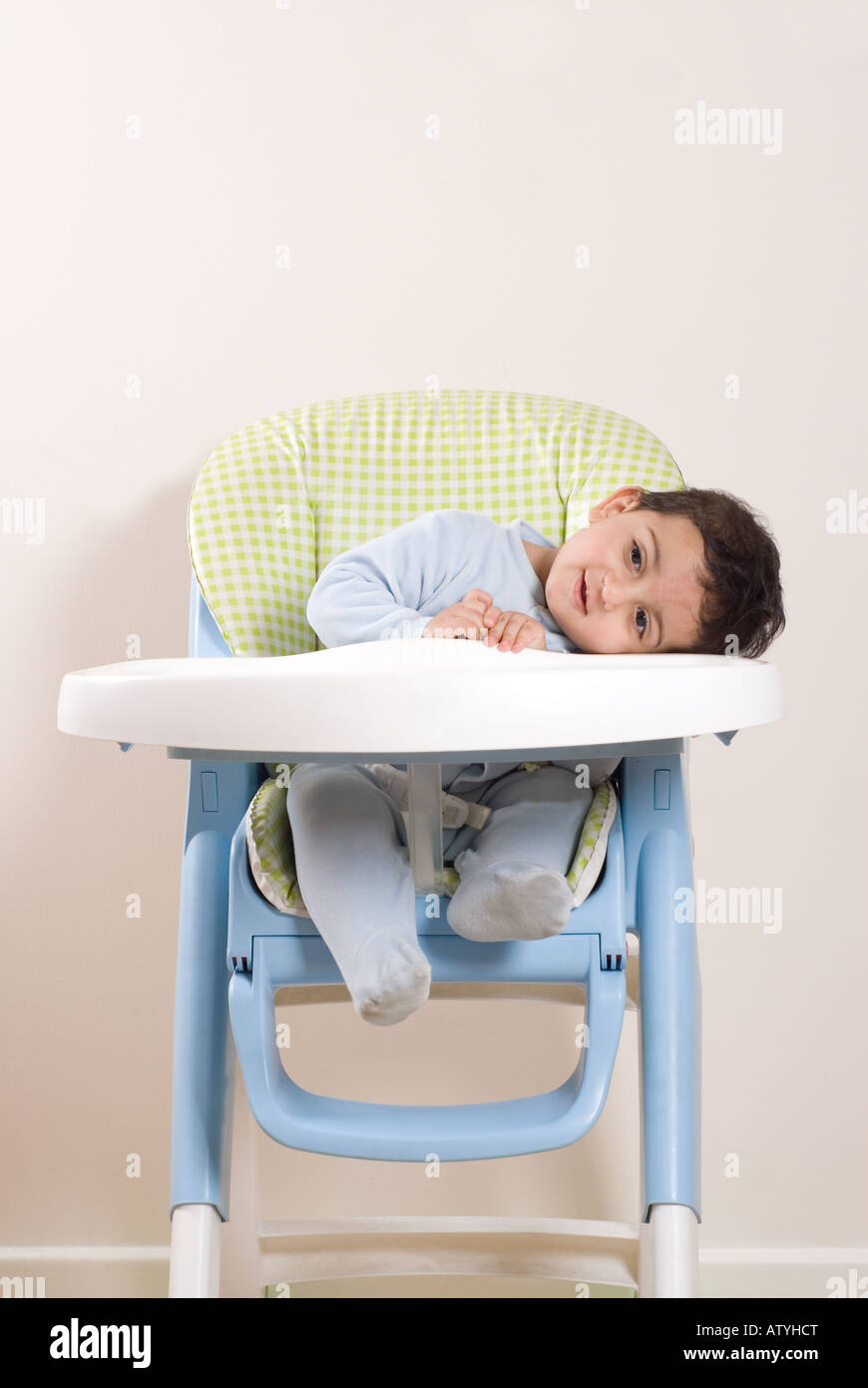 One year old boy sitting on a highchair 