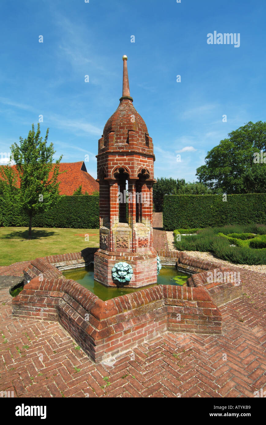 Tudor walled garden Cressing Temple Essex created originally c.1600 new garden1996 & features brick fountain & roof of historical Wheat Barn beyond UK Stock Photo