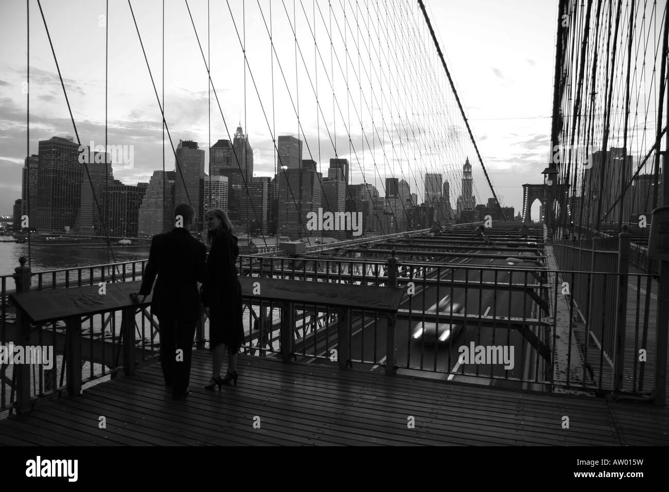 A couple on the Brooklyn Bridge with the Manhatten skyline behind Stock ...